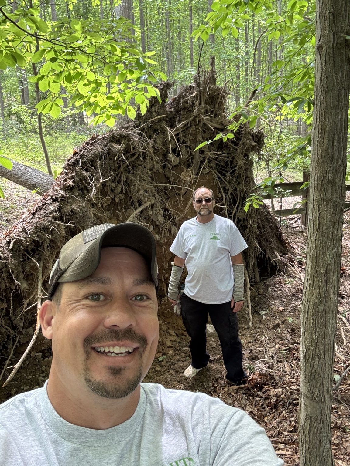 Andy Wright on a tree cleanup job beside a large uprooted tree
